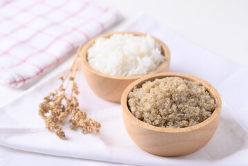 Cooked brown quinoa seeds and raw quinoa seeds in a wooden bowl, Healthy vegan food