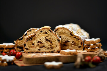 Slices of German Stollen cake, a fruit bread with nuts, spices, and dried or candied fruits, coated...