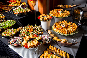 Beautifully decorated catering banquet table with different food snacks and appetizers with sandwich