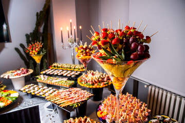 Beautifully decorated catering banquet table with different food snacks and appetizers with sandwich