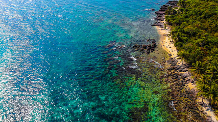 Aerial view of beautiful landscape, tourism boats, and people swimming on the sea and beach on May Rut island (a tranquil island with beautiful beach) in Phu Quoc, Kien Giang, Vietnam.