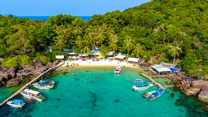 Aerial view of beautiful landscape, tourism boats, and people swimming on the sea and beach on May Rut island (a tranquil island with beautiful beach) in Phu Quoc, Kien Giang, Vietnam.