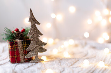 Christmas gift on a white knitted background with glitter christmas tree
