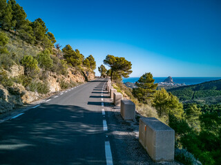 Mountain road with protection bollards near ifach boulder