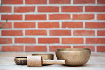 Tibetan singing bowls with sticks on the wall background - music instruments for meditation, relaxation after yoga practice and healing massage. High quality photo