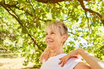 Smiling elderly woman doing a yoga breathing exercise