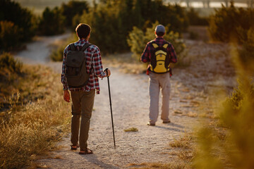 two men hikers enjoy a walk in nature, sunset time in summer