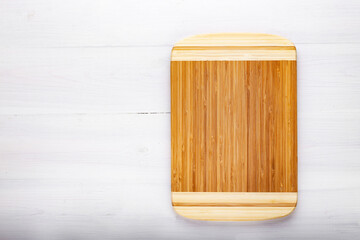 Naklejka na ściany i meble Cutting kitchen board on white wooden table. Space for text.