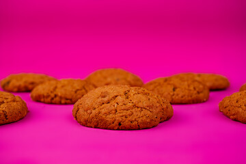 Oatmeal cookies with raisins and nuts inside on a purple background. Delicious homemade cakes made from natural ingredients. Space for text.
