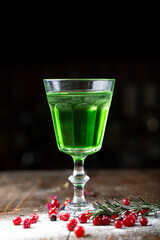 Absinthe is poured into a beautiful old glass, stands on the bar counter.