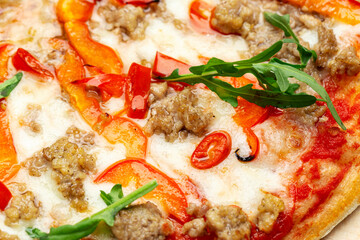 Delicious pizza, which includes tomatoes, cheese, arugula, peppers.