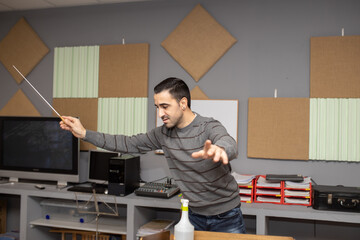 conductor with baton rehearsing in studio