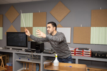 conductor with baton rehearsing in studio