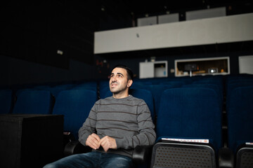 man alone watching movie in empty cinema