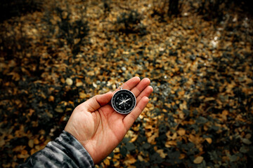 the compass in my hand in the forest
