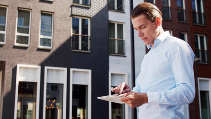 Fototapeta premium Young and attractive freelancer walking outdoor. Office worker or businessperson. Business and real estate.