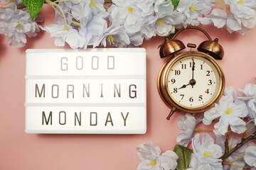 Good Morning Monday word in light box with Flowers Decoration on pink background