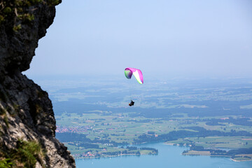  Paraglider flying over lake Forggensee in Bavarian mountains