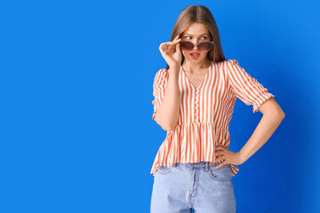 Beautiful woman with stylish sunglasses on color background