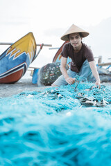 Portrait of a young male fisherman preparing a fishing net