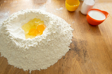 Egg yolk with flour. fresh eggs, put in the dough hole. Preparation of dough for dumplings.