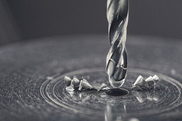 metal drill bit make holes in steel billet with lubricating liquid on industrial drilling machine....