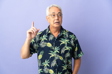 Naklejka premium Middle age Brazilian man isolated on purple background thinking an idea pointing the finger up