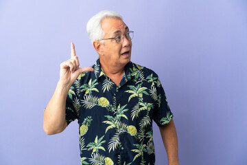 Middle age Brazilian man isolated on purple background intending to realizes the solution while lifting a finger up