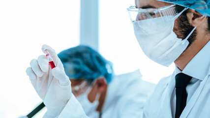close up. virologist holds an ampoule with a new vaccine.
