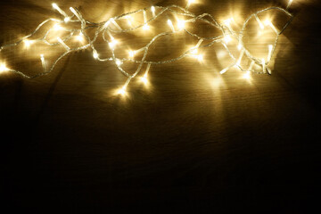 Garland of lamps christmas lights on oak wood background with copy space