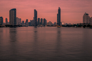 Naklejka premium The high angle background of the city view with the secret light of the evening, blurring of night lights, showing the distribution of condominiums, dense homes in the capital community