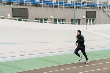 Handsome athletic sportsman running while working out