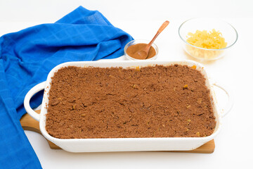 step-by-step recipe for the holiday of Hanukkah, a traditional sweet Kugel pie with noodles and custard, shortbread cocoa crumbs on top. on a light background in a baking dish
