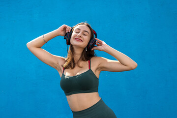 Fototapeta premium Happy fitness woman in sportear listening to music isolated