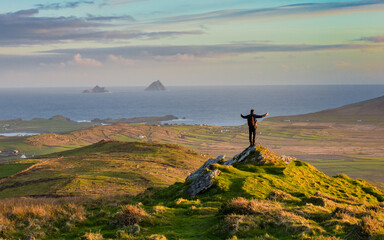 silhouette of a person standing on top of mountain at the  West Ireland coast