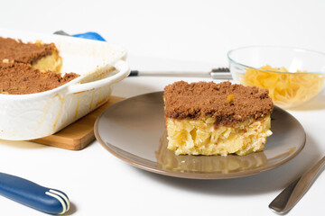 step-by-step recipe for the holiday of Hanukkah, a traditional sweet Kugel pie with noodles and custard, shortbread cocoa crumbs on top. on a light background in a baking dish