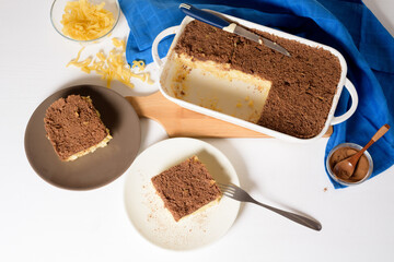 Hanukkah holiday, traditional sweet Kugel pie with noodles and custard, shortbread cocoa crumbs on top. on a light background in a baking dish. pie slices on a plate