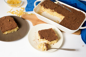 Hanukkah holiday, traditional sweet Kugel pie with noodles and custard, shortbread cocoa crumbs on top. on a light background in a baking dish. pie slices on a plate