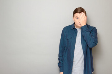 Portrait of anxious man covering half of his face with hand