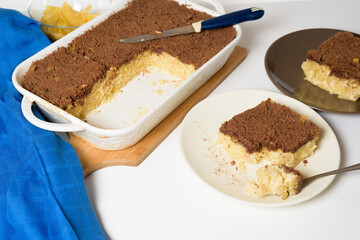 Hanukkah holiday, traditional sweet Kugel pie with noodles and custard, shortbread cocoa crumbs on top. on a light background in a baking dish. pie slices on a plate