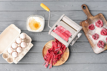 Pasta maker with dough and eggs on kitchen table