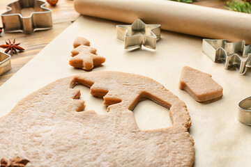 Fresh dough for gingerbread cookies and cutters on table