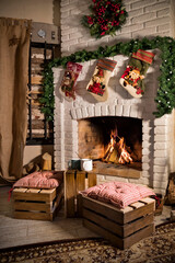 White brick fireplace with Christmas wreath, garland and Santa socks. Nearby are two ottomans and cups of coffee