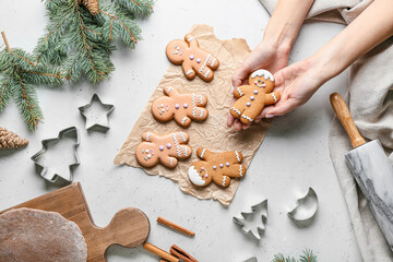 Female hands with gingerbread cookies on white background, top view - obrazy, fototapety, plakaty