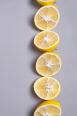 Fototapeta na wymiar Yellow slice lemon on a gray background. Space for text. Close up.