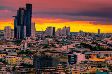 Fototapeta premium The high angle background of the city view with the secret light of the evening, blurring of night lights, showing the distribution of condominiums, dense homes in the capital community