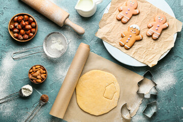 Fresh dough for gingerbread cookies, cutters and ingredients on color background