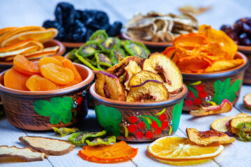 Obraz na płótnie Canvas Organic Healthy Assorted Dried Fruit Mix close up. Dried fruit snacks. dried apples, mango, feijoa, dried apricots, prunes top view
