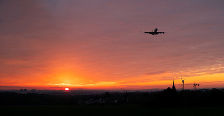 Airplane approaching to Luxembourg airport at sunset.