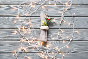Napkin with mistletoe for Christmas dinner on wooden background